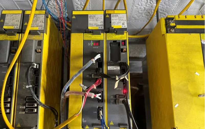 FANUC servo amplifier bank containing A06B-6240-H105 and A06B-6240-H115 units