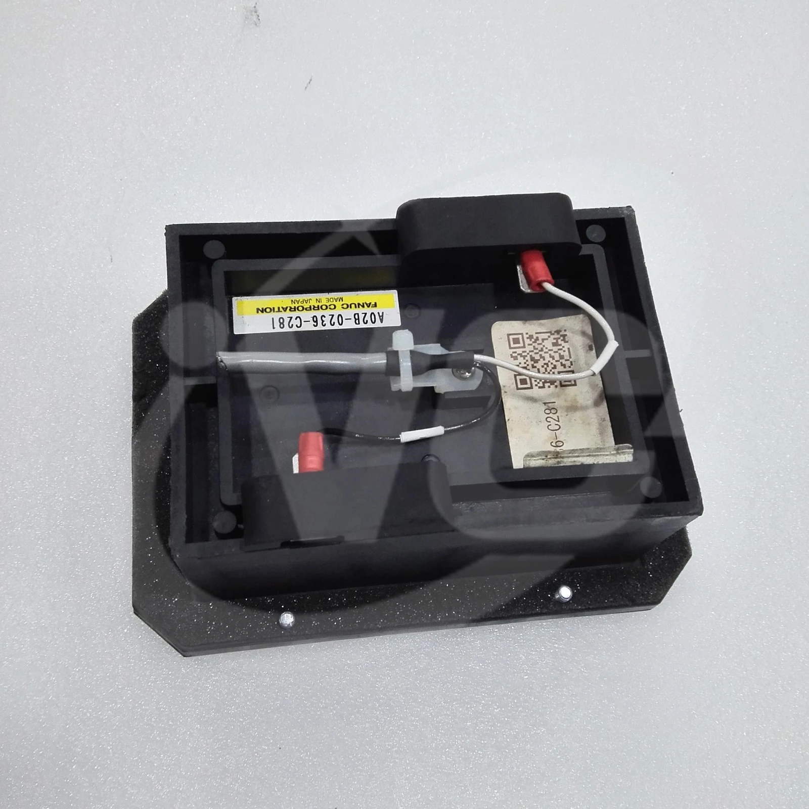 FANUC A02B-0236-C281 external battery case with the cover removed, showing internal wiring and retaining straps at an angle